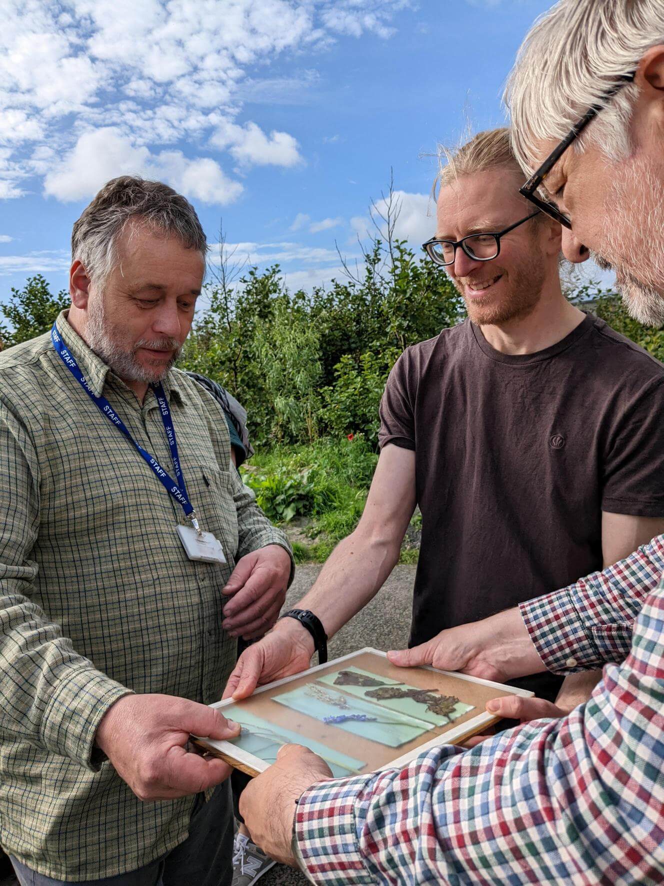Three Men Outside Creating Art With Nature at even